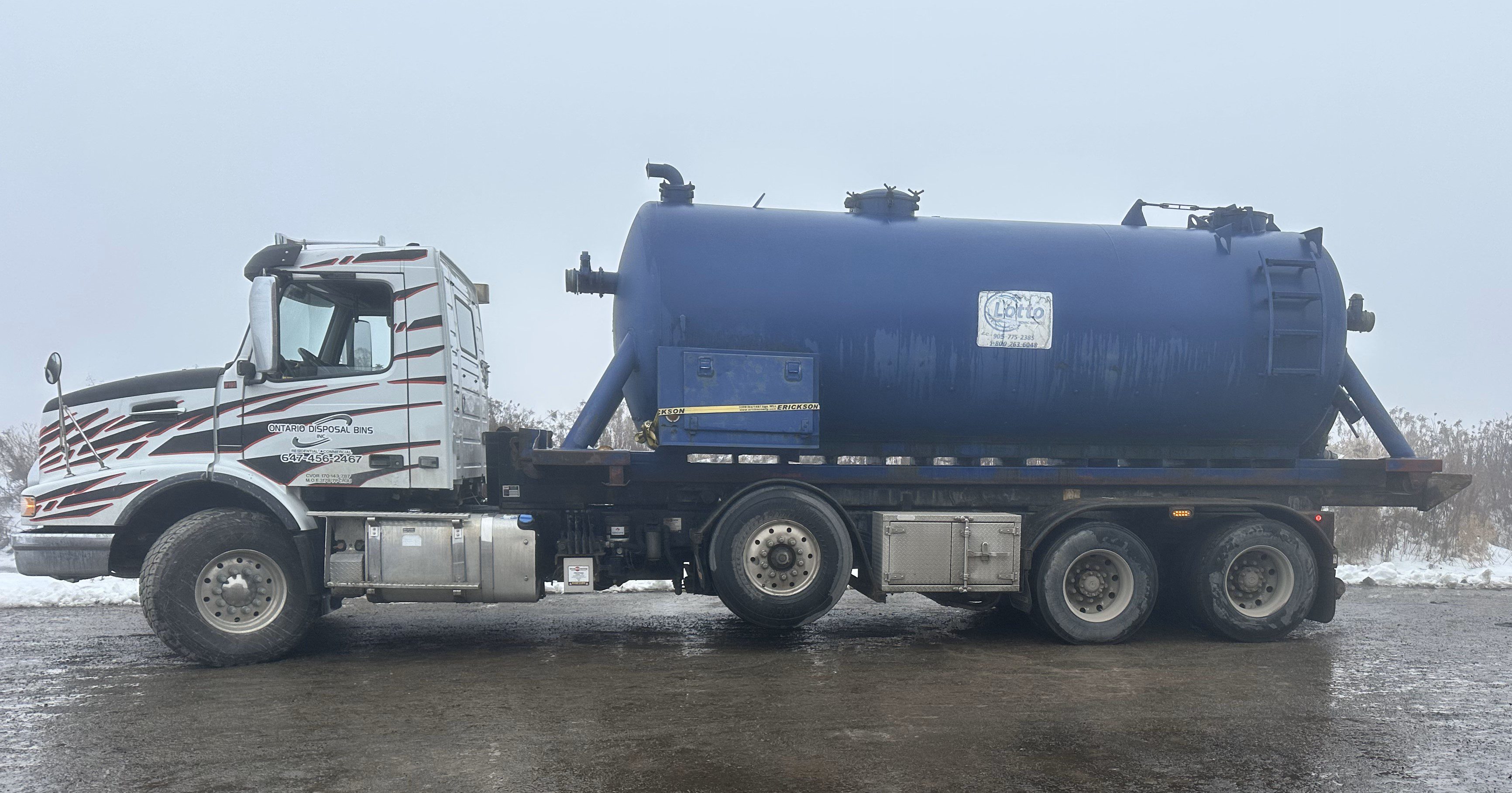 Septic tank odb A large blue truck is driving down the road.